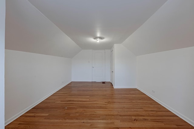 additional living space featuring lofted ceiling, wood finished floors, and baseboards