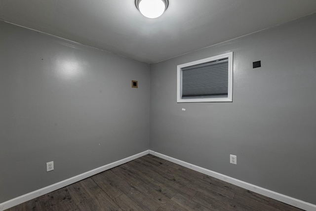 spare room featuring dark wood-style floors and baseboards