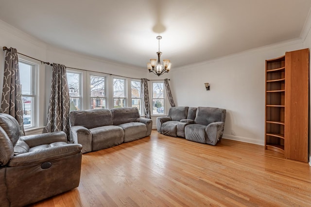 living area with crown molding, an inviting chandelier, baseboards, and light wood-style floors