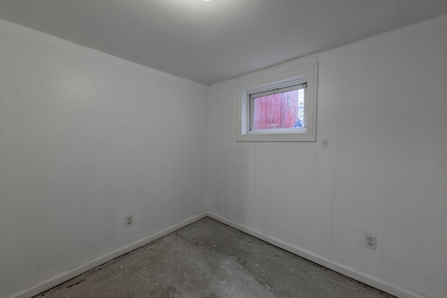 unfurnished room featuring baseboards and concrete flooring