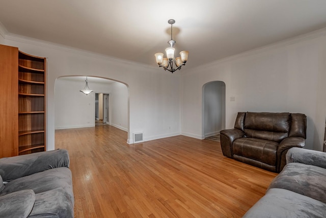 living room with arched walkways, light wood-style flooring, a chandelier, and visible vents