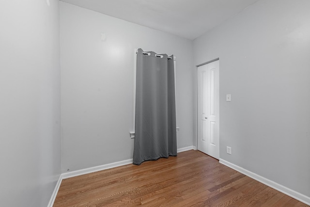 empty room featuring baseboards and wood finished floors