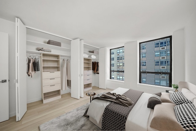 bedroom with multiple closets and light wood-style flooring