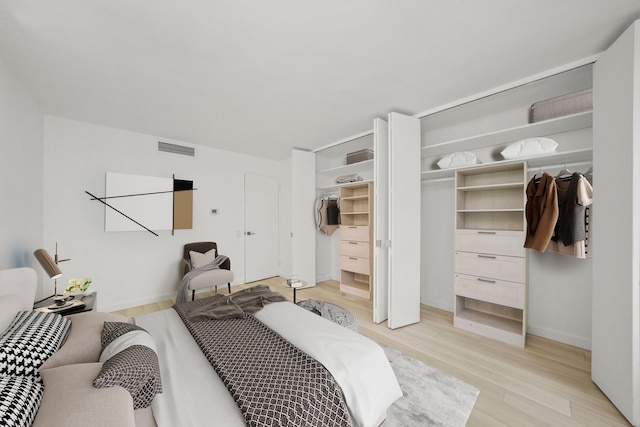 bedroom with light wood-type flooring, visible vents, and baseboards