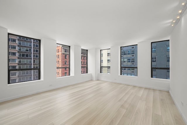 spare room featuring wood finished floors and baseboards