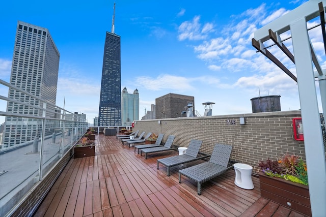 wooden deck featuring a city view and a pergola