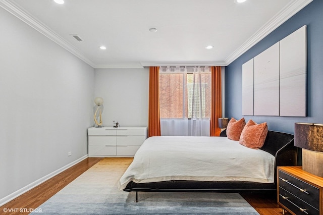 bedroom with baseboards, wood finished floors, and ornamental molding