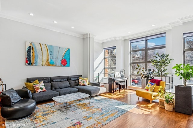 living area featuring recessed lighting, a healthy amount of sunlight, wood finished floors, and crown molding