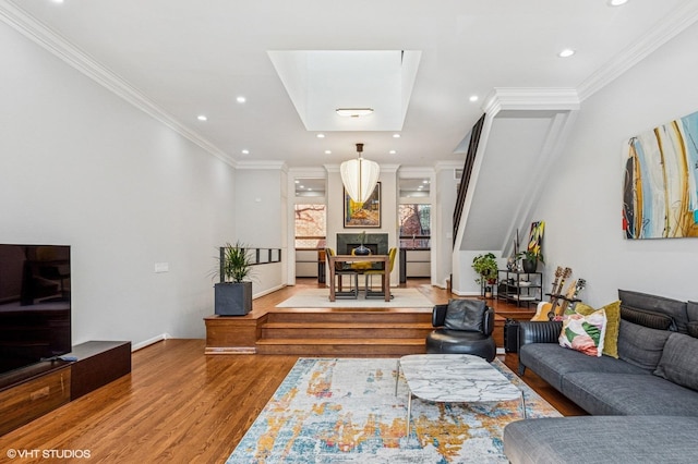 living area featuring recessed lighting, wood finished floors, a fireplace, and ornamental molding