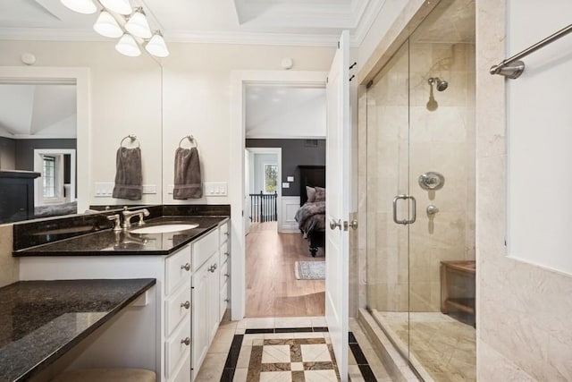bathroom featuring ornamental molding, a shower stall, vanity, and ensuite bath