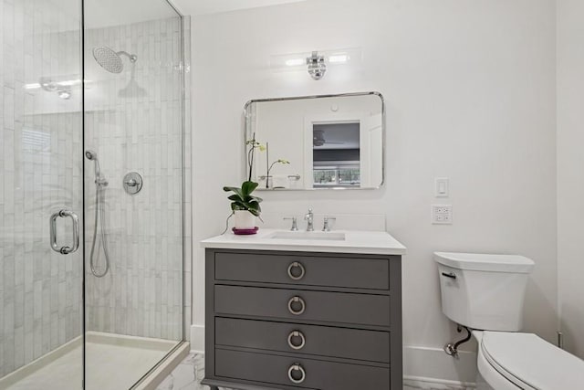 bathroom featuring a shower stall, baseboards, toilet, vanity, and marble finish floor