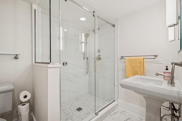 full bath with a marble finish shower, marble finish floor, toilet, and baseboards