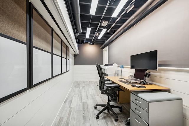 office area with wood finished floors and a wainscoted wall