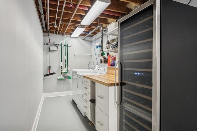 unfinished basement featuring washing machine and clothes dryer, freestanding refrigerator, and baseboards