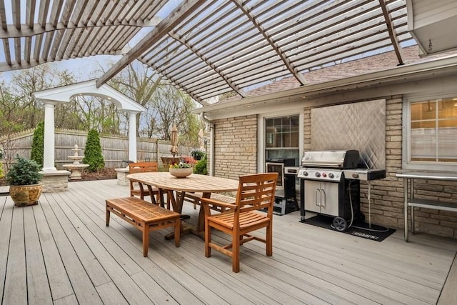 deck featuring fence, outdoor dining space, area for grilling, and a pergola