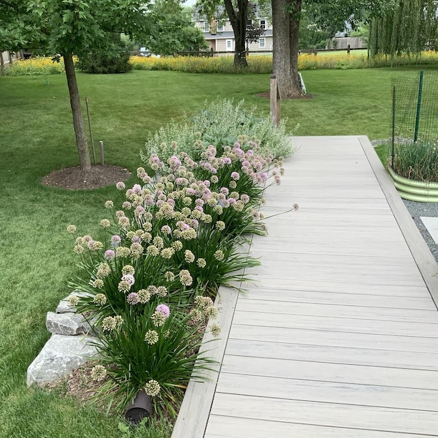 view of dock with a yard and fence