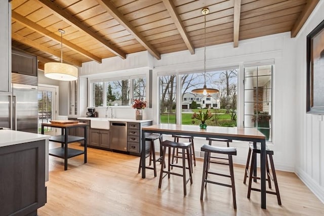 sunroom with beam ceiling and a sink