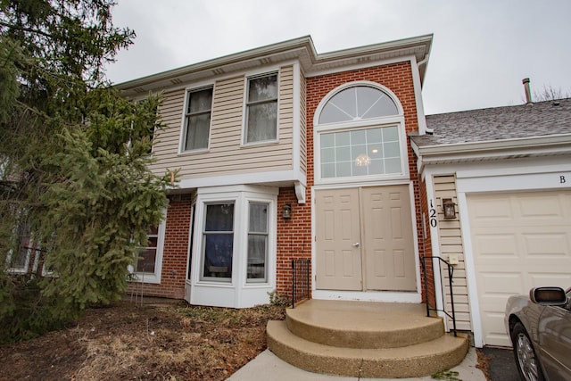 view of front facade with a garage and brick siding