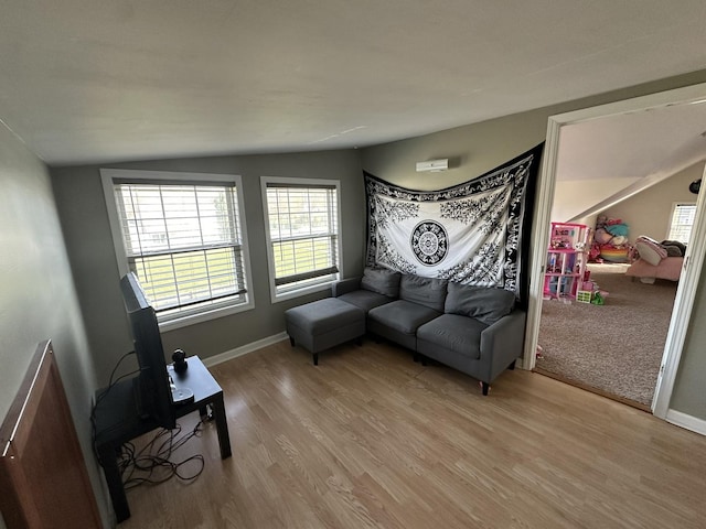 sitting room with vaulted ceiling, baseboards, and wood finished floors