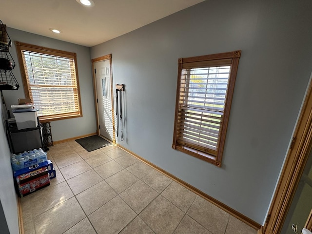 doorway featuring tile patterned flooring, baseboards, a wealth of natural light, and recessed lighting