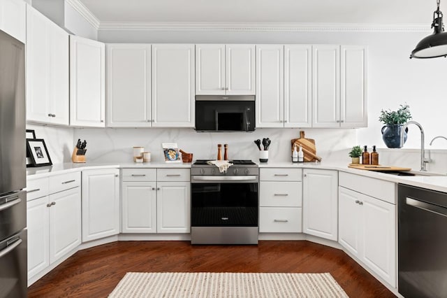 kitchen featuring a sink, light countertops, appliances with stainless steel finishes, dark wood-style floors, and crown molding