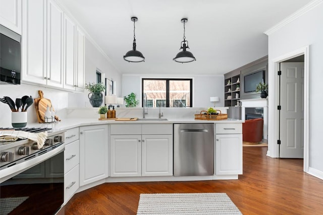 kitchen with appliances with stainless steel finishes, crown molding, a sink, and white cabinetry