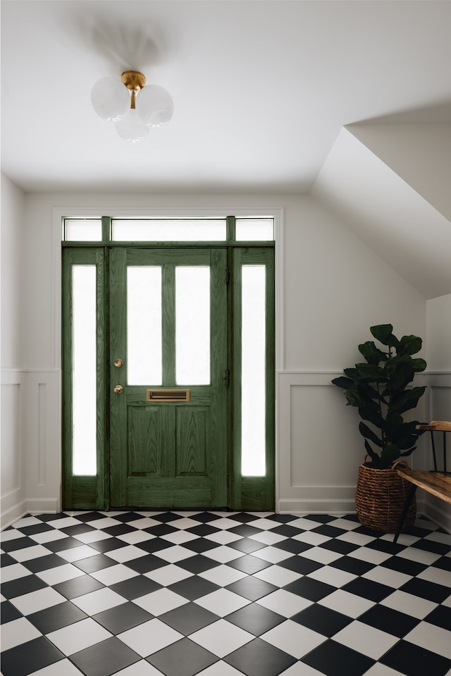 foyer featuring plenty of natural light, a decorative wall, and light floors