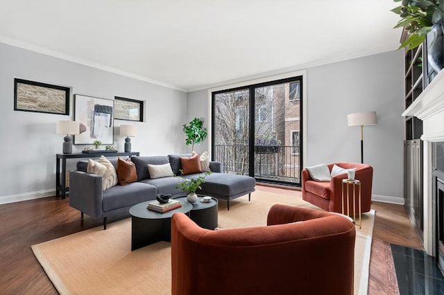 living room featuring a fireplace with flush hearth, ornamental molding, baseboards, and wood finished floors