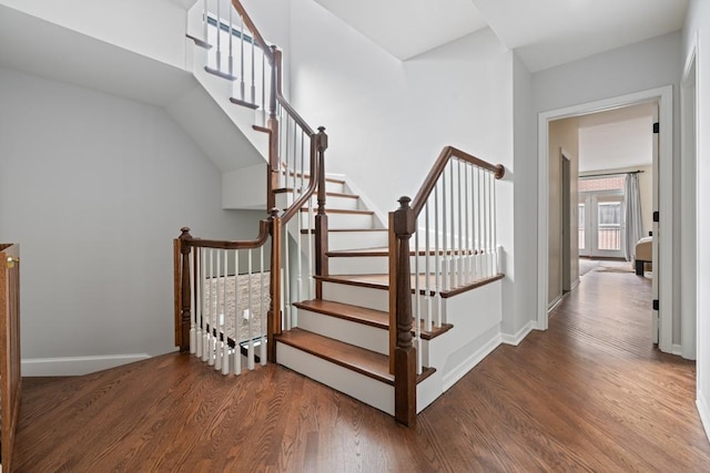 staircase featuring baseboards and wood finished floors