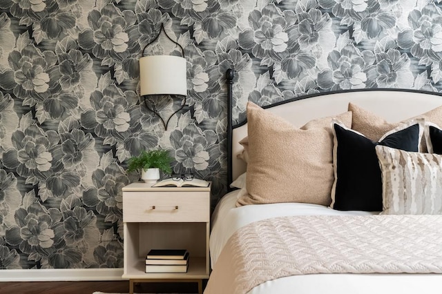 bedroom with wood finished floors, baseboards, and wallpapered walls