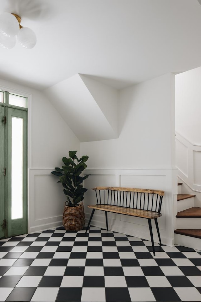 additional living space with light floors, stairway, plenty of natural light, and a decorative wall