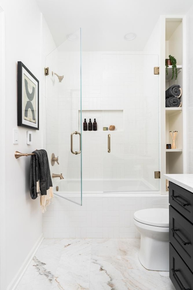 bathroom with toilet, marble finish floor, tiled shower / bath, and vanity