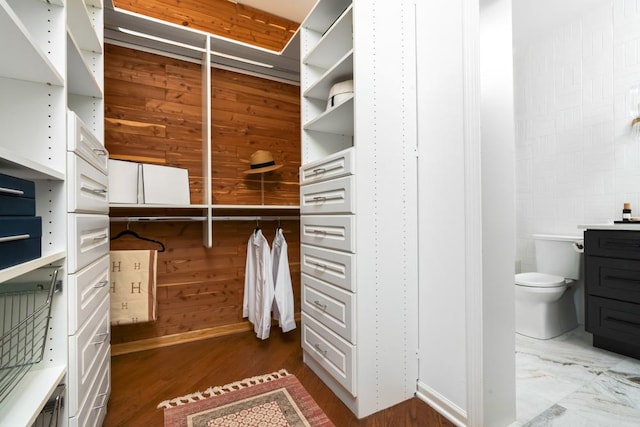 walk in closet featuring marble finish floor