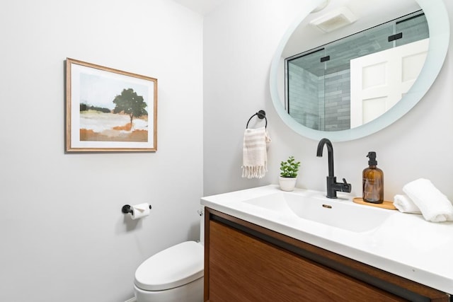 full bath with a shower stall, vanity, and toilet