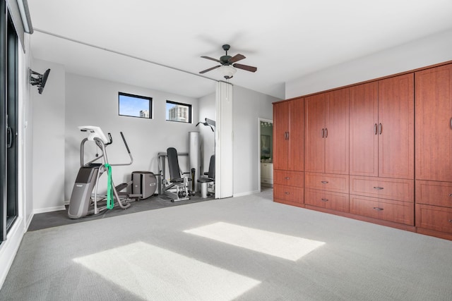 workout room with a ceiling fan, baseboards, and carpet flooring