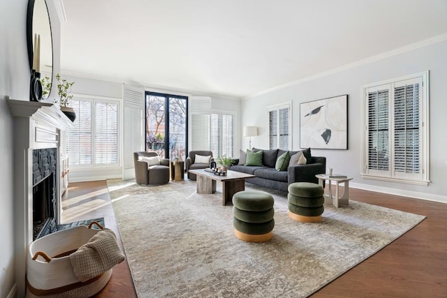 living area featuring ornamental molding, baseboards, a fireplace with flush hearth, and wood finished floors