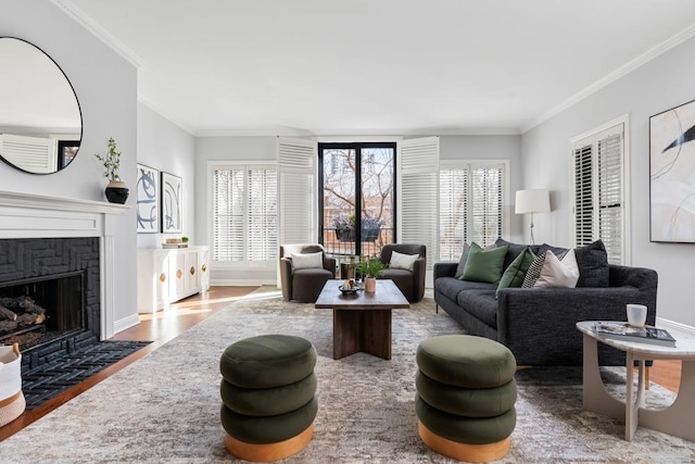 living room with crown molding, a fireplace, baseboards, and wood finished floors