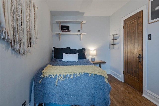 bedroom featuring baseboards and wood finished floors