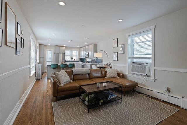 living room with a baseboard radiator, recessed lighting, wood finished floors, cooling unit, and baseboards