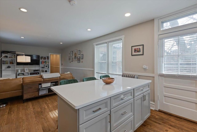 kitchen featuring a kitchen island, light countertops, dark wood-type flooring, and recessed lighting