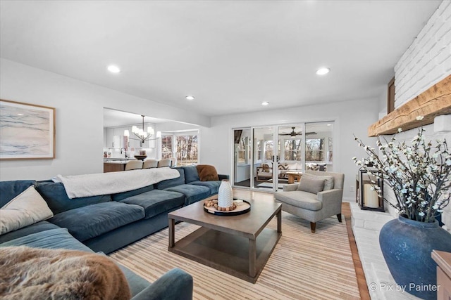 living room featuring ceiling fan with notable chandelier, a wealth of natural light, and recessed lighting