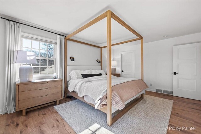 bedroom featuring baseboards, visible vents, and light wood-style floors