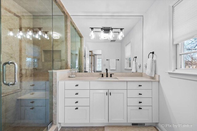 full bathroom with baseboards, visible vents, a shower stall, and vanity