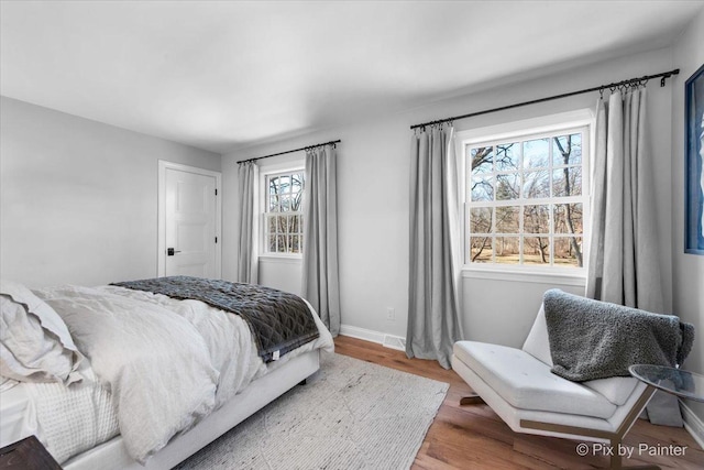 bedroom with baseboards and wood finished floors