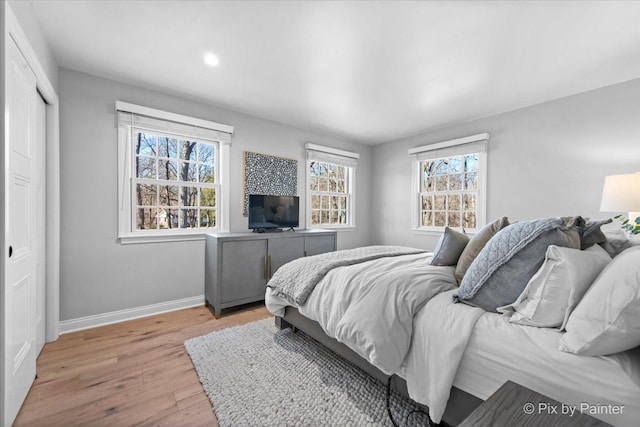 bedroom with light wood-style floors, recessed lighting, a closet, and baseboards