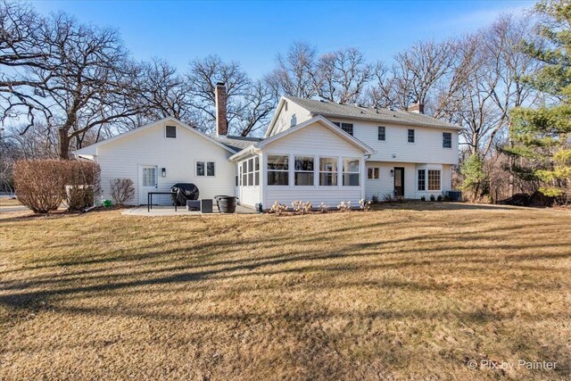 back of house featuring a patio, central AC, a sunroom, a yard, and a chimney