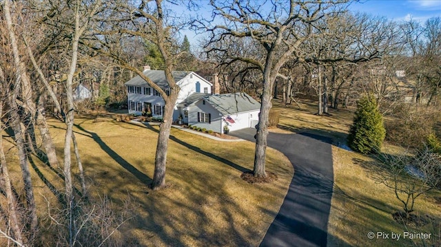 colonial inspired home with a garage, aphalt driveway, and a front yard