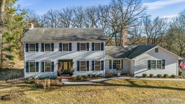 view of front of property with a front yard and a chimney