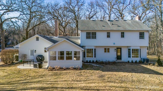 rear view of house featuring central air condition unit, a shingled roof, a lawn, a chimney, and a patio area