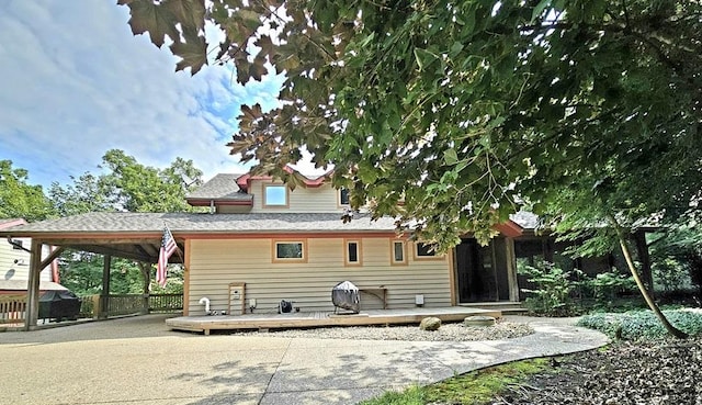 rear view of house with a deck and driveway